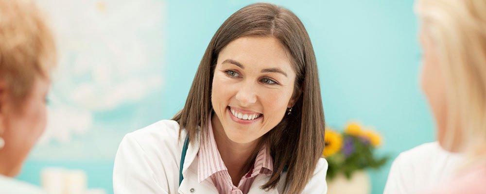 young female clinician smiling at two clients